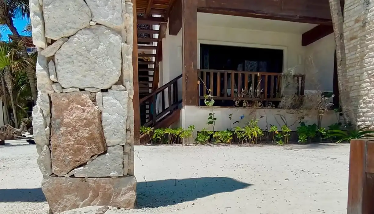 Columna de piedra caliza y, al fondo, la escalera de madera y la terraza cubierta