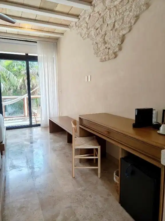 Escritorio de madera junto al ventanal del balcón.