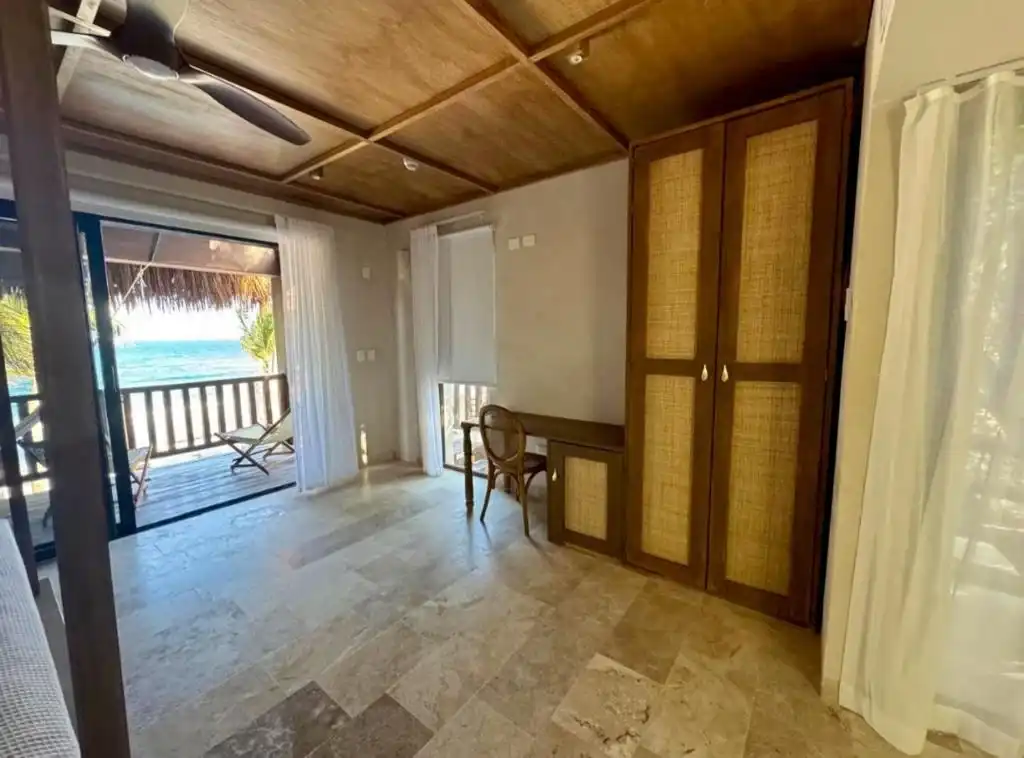 Habitación con techo de madera, clóset y salida al balcón.