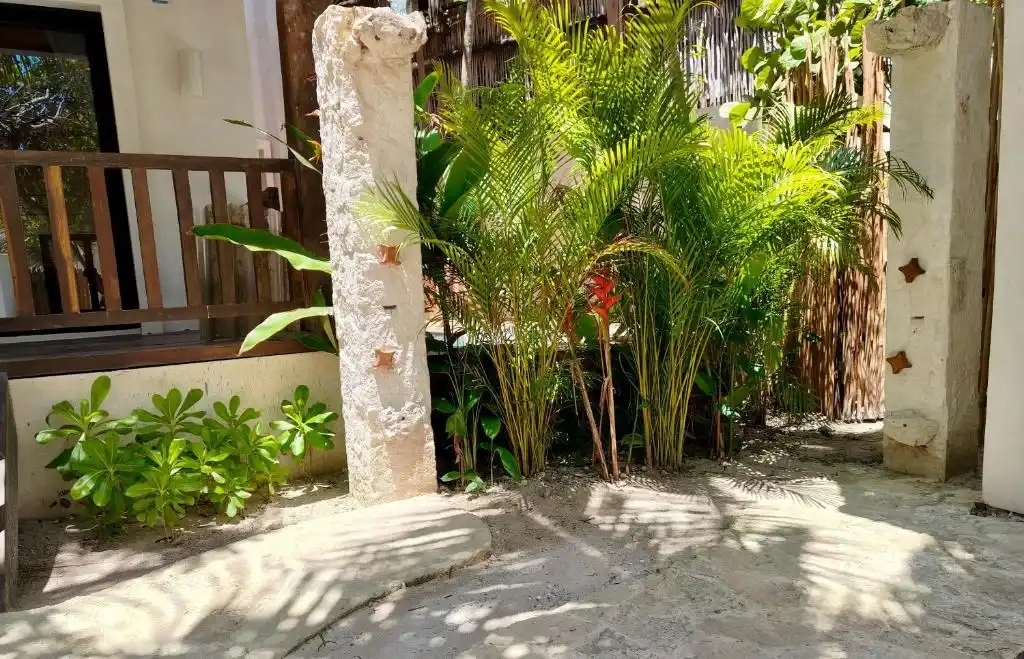 Columna de piedra y vegetación junto a la terraza.