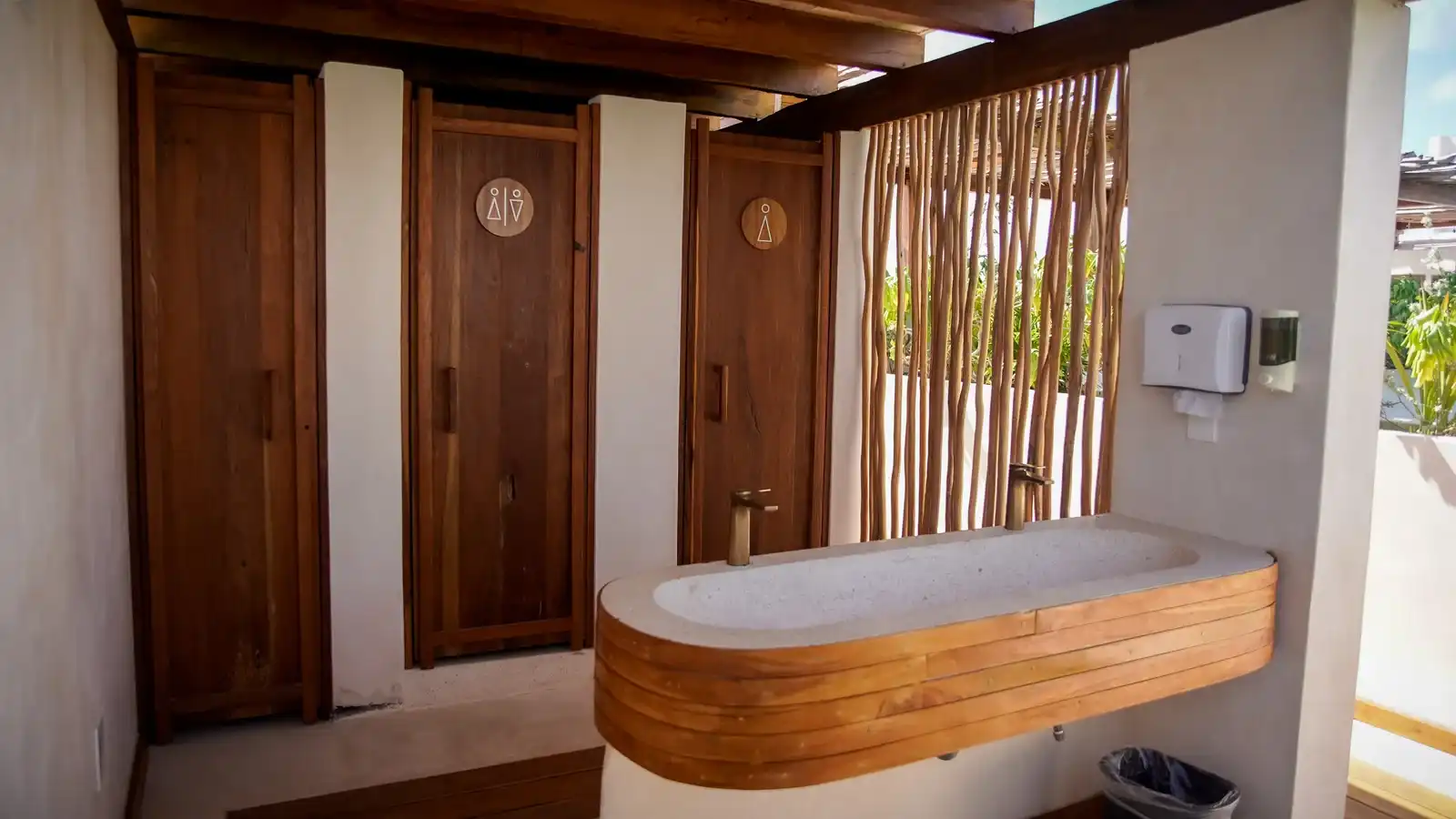 Baño con puertas de madera y una tina de obra con borde de madera.