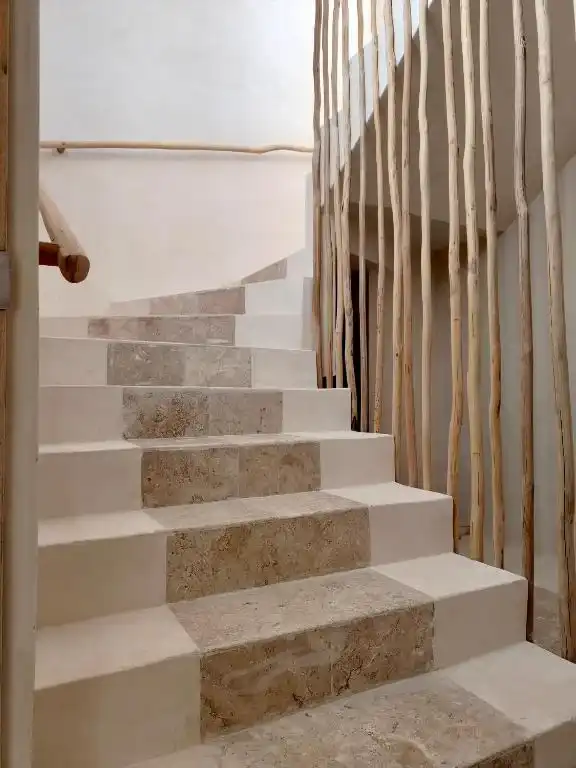 Escalera de piedra con barandal de troncos.
