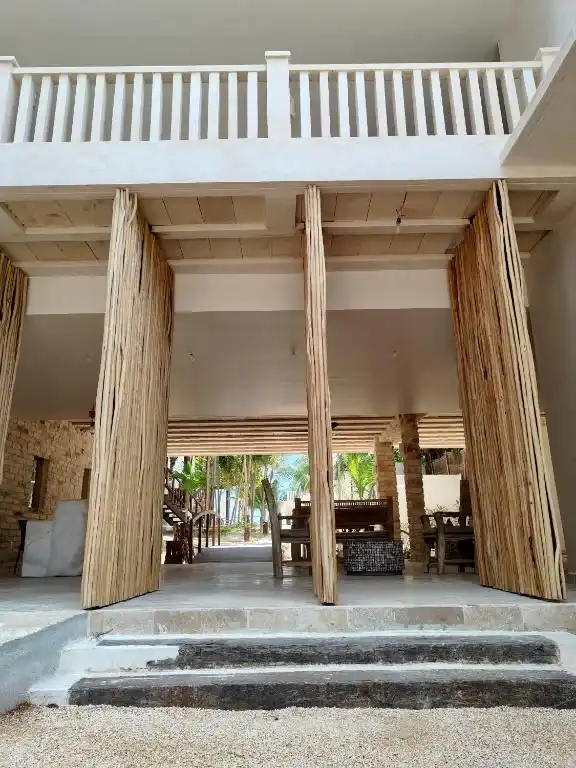 Fachada con puertas de madera abiertas y escalones de piedra.