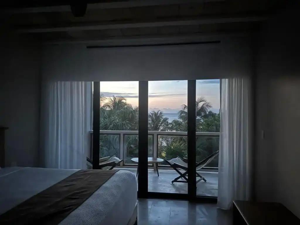 Habitación en penumbra, con el ventanal abierto al atardecer.