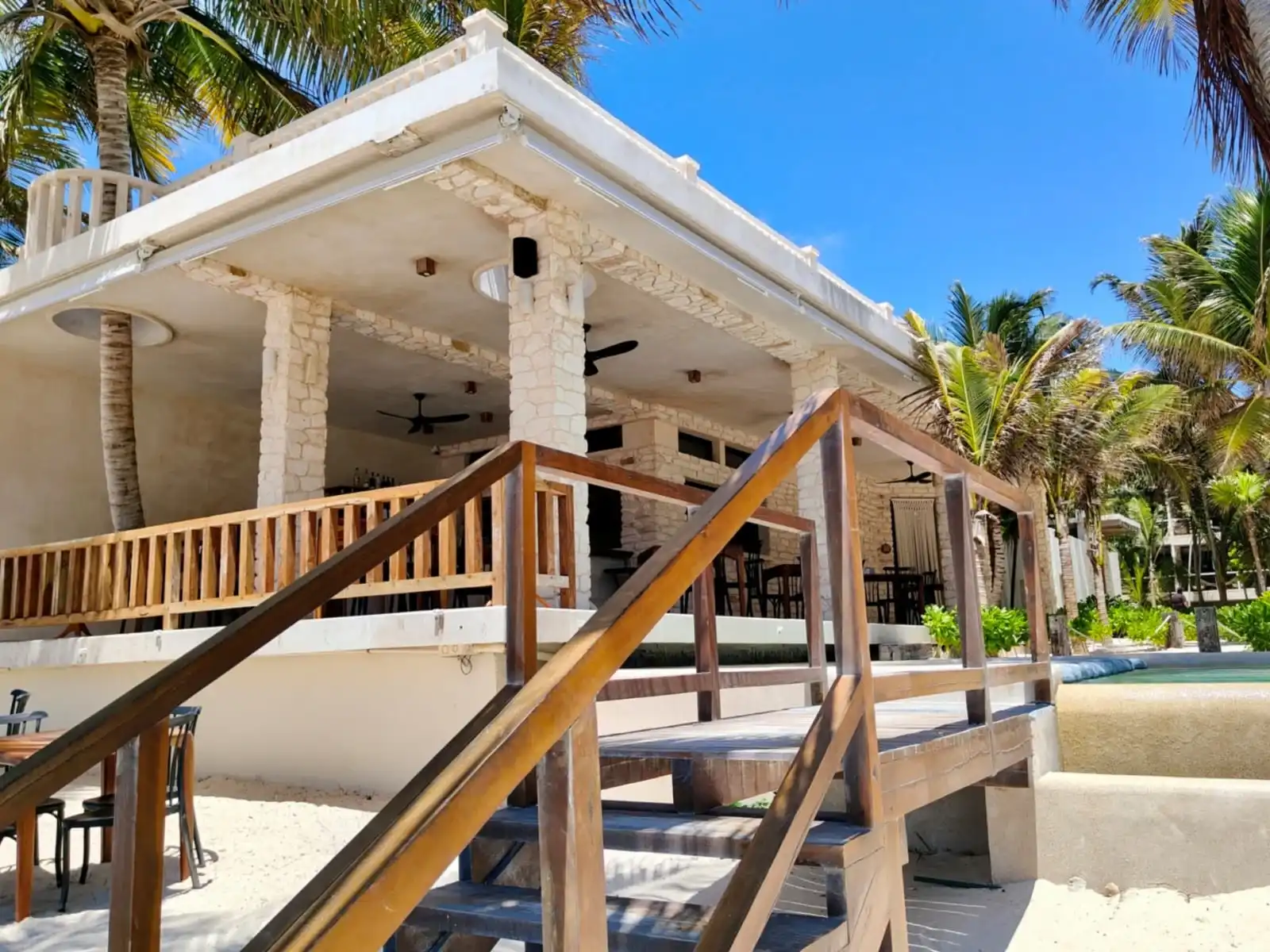 La palapa del restaurante, con su escalera y su barandal de madera entre palmeras
