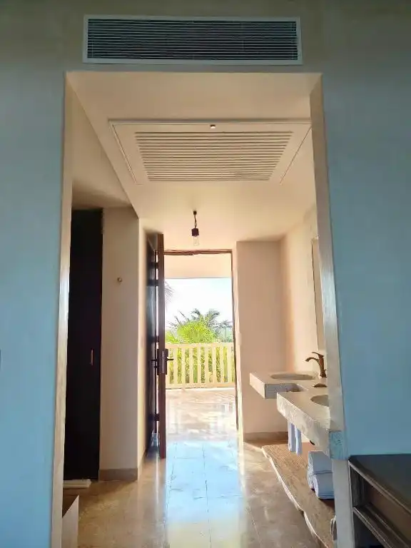 Pasillo interior hacia el lavabo, con la puerta abierta al fondo.