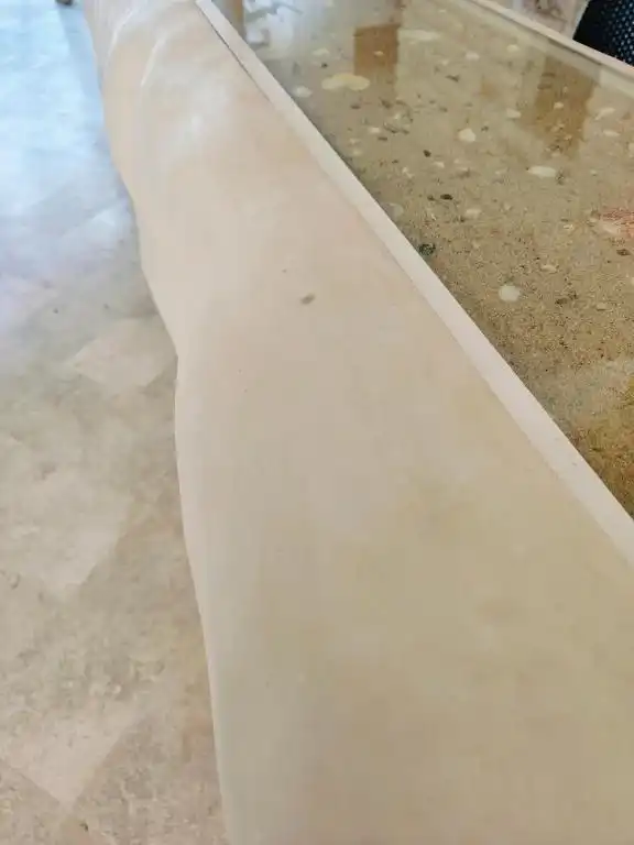 Borde de la alberca, con arena y conchas incrustadas.