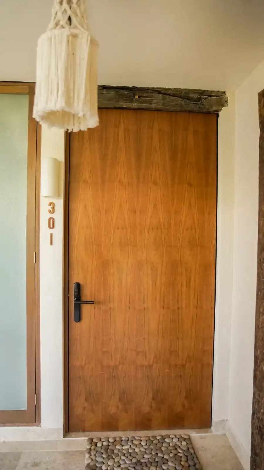 Puerta de madera de la habitación 301, con un colgante de macramé encima.