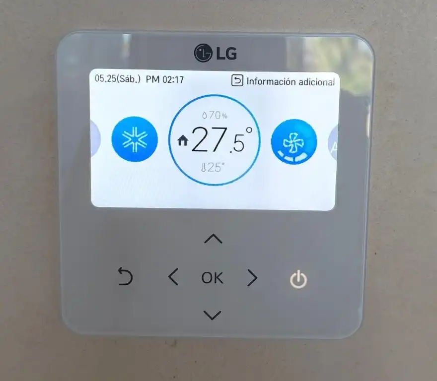 El termostato del aire acondicionado de la habitación, marcando 27.5 grados.